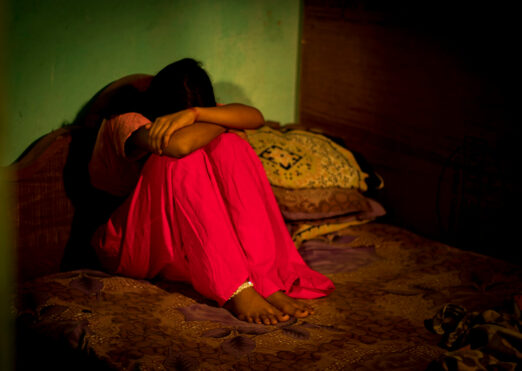 Sad girl sitting on bed